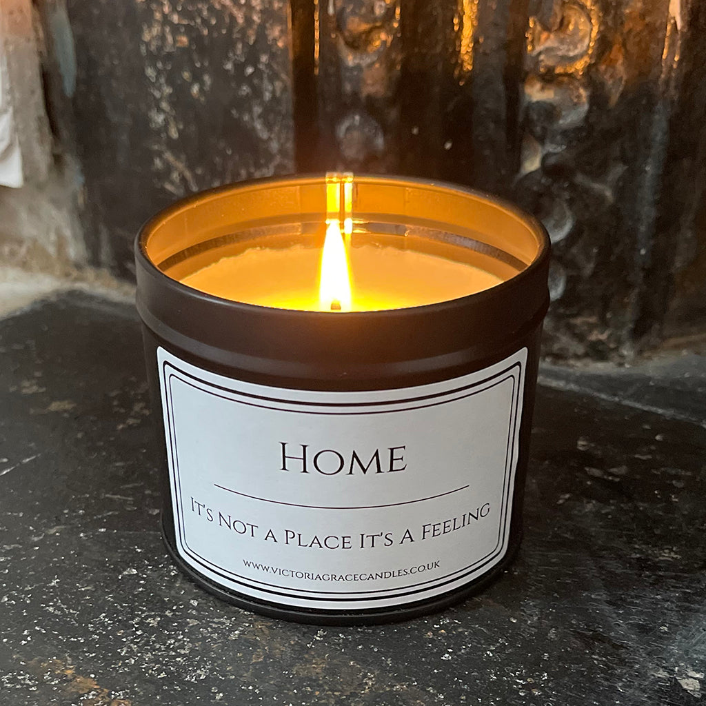 Black tin candle with the words Home its not a place its a feeling