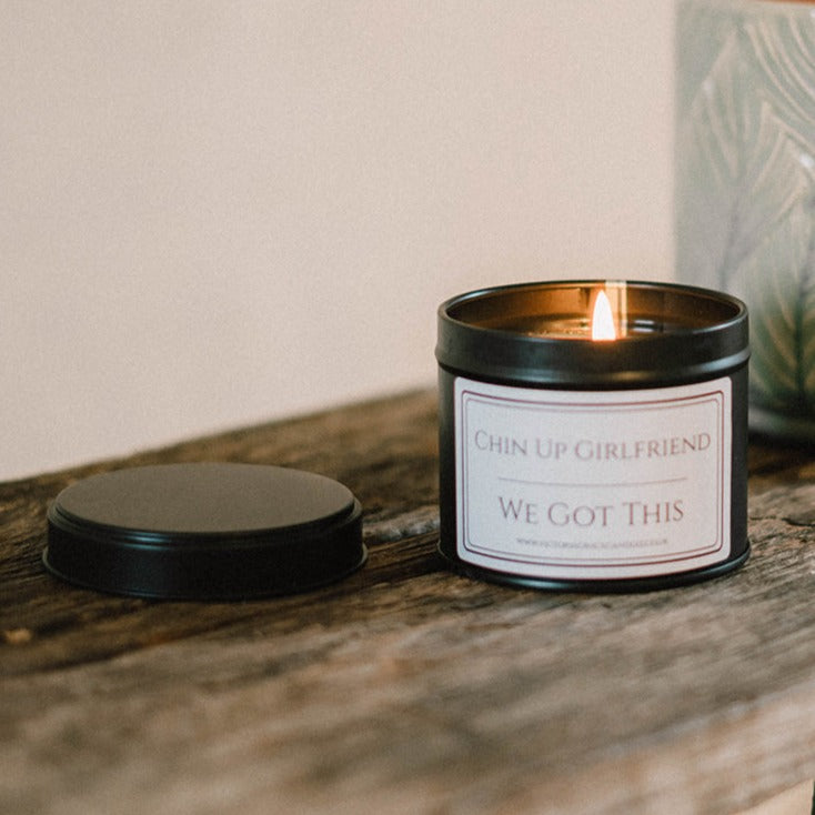 Chin Up Girlfriend We Got This black tin Candle in a rustic setting
