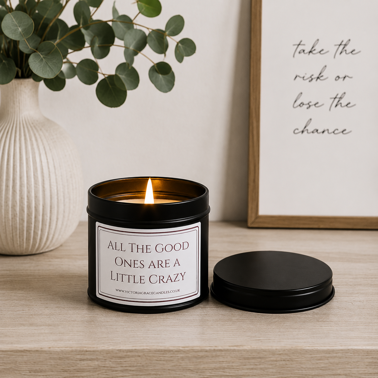 Luxury black soy wax candle displayed on a modern wooden sideboard with eucalyptus, neutral décor and soft natural light.