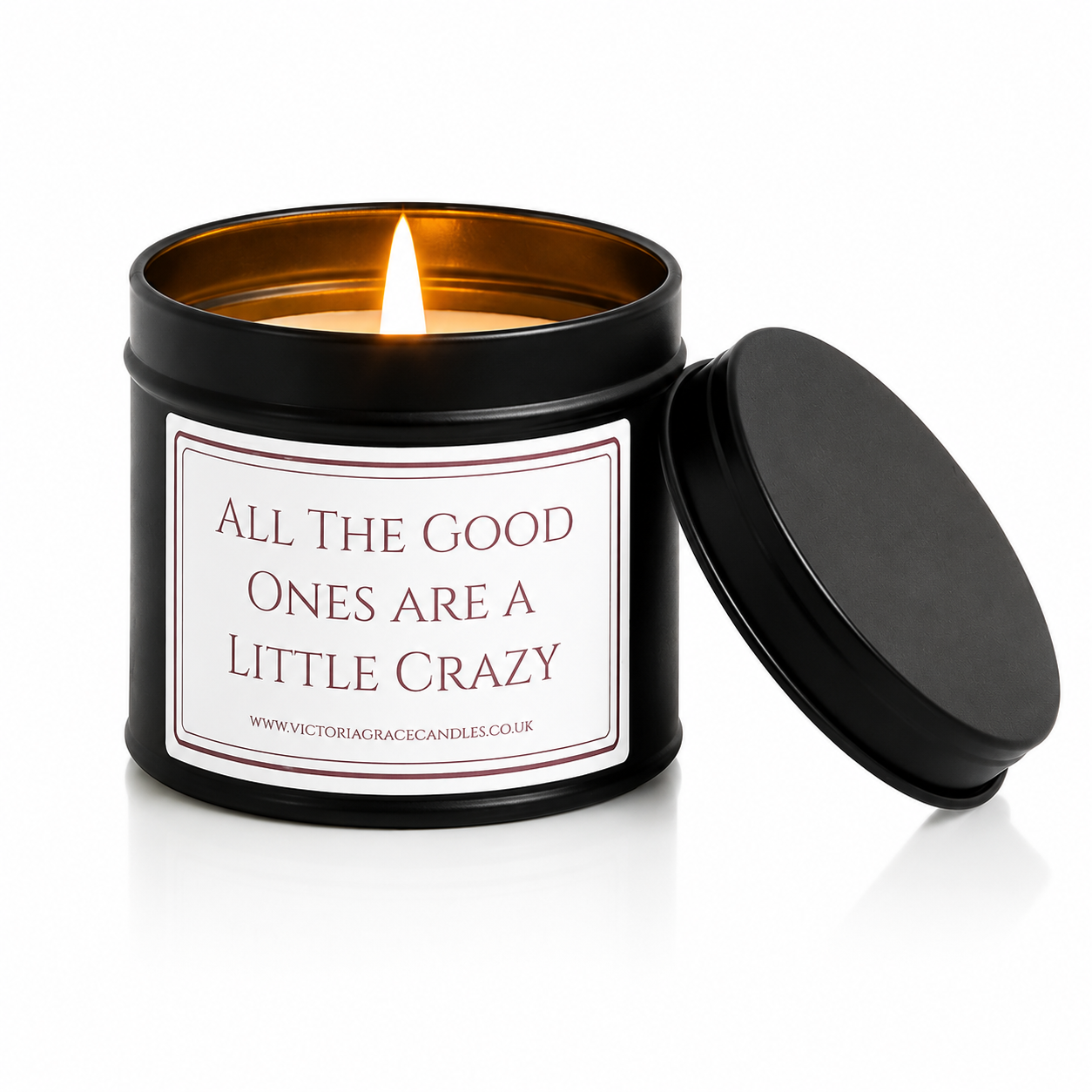 Luxury black soy wax candle with the words "All the Good Ones Are a Little Crazy" on a white background with the black lid resting beside the candle.