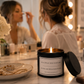 Black tin candle with the word be as picky with your men as you are with your selfies on it in a dressing room environment with a lady putting makeup on in the background.
