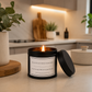 Black tin candle with the word be as picky with your men as you are with your selfies on it in a modern kitchen