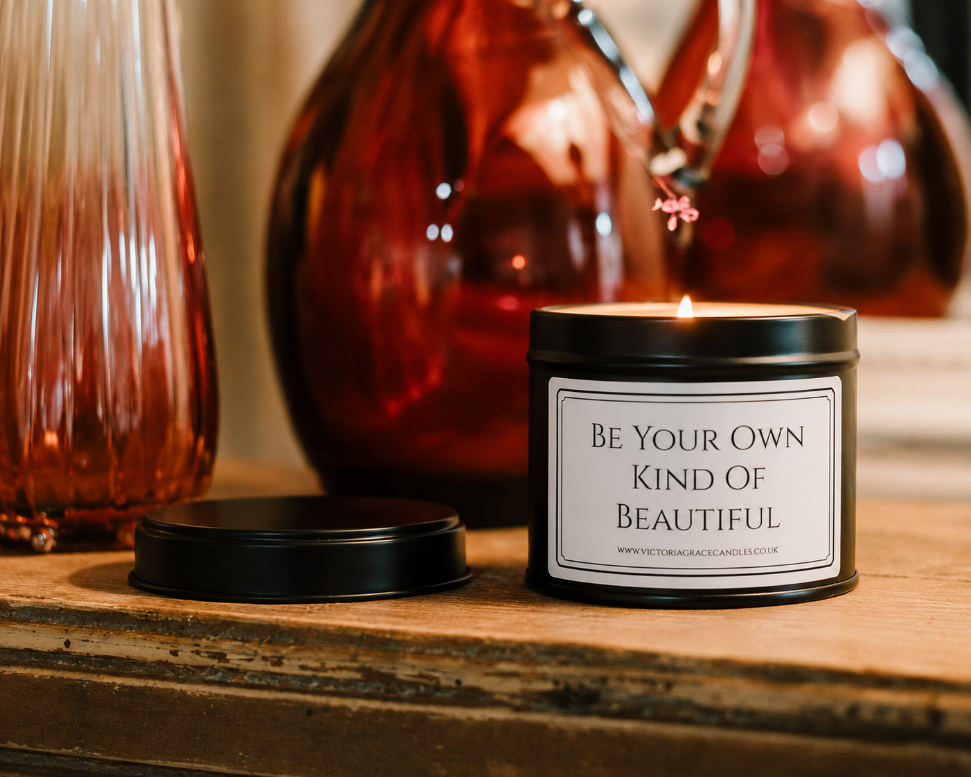 Luxury inspirational soy wax candle displayed on a rustic wooden table with warm amber glass vases, creating a calm and elegant atmosphere.
