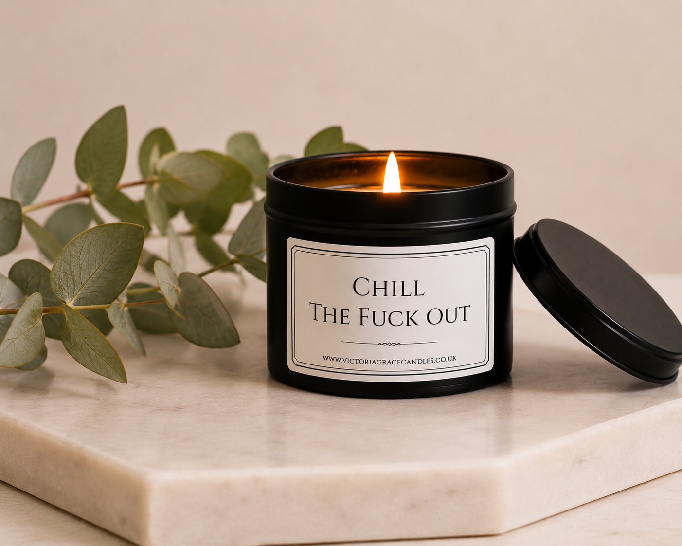 Luxury soy wax candle on a marble surface with eucalyptus leaves, creating a calming spa-inspired atmosphere.