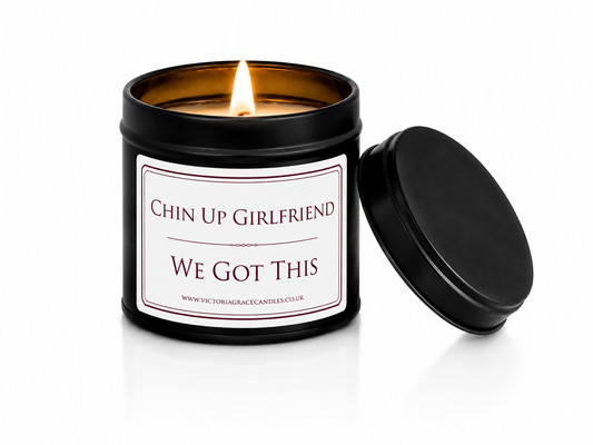 Luxury black soy wax candle with the words "Chin Up Girlfriend, We Got This" displayed on a white background with the black lid leaning against the right-hand side of the candle.