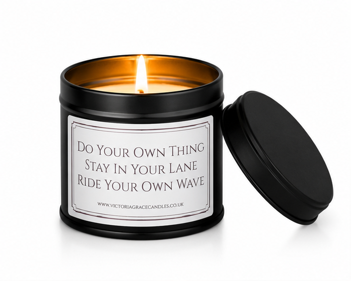 Luxury black soy wax candle with the words "Do Your Own Thing, Stay In Your Lane, Ride Your Own Wave" on a white background with the black lid resting beside the candle.
