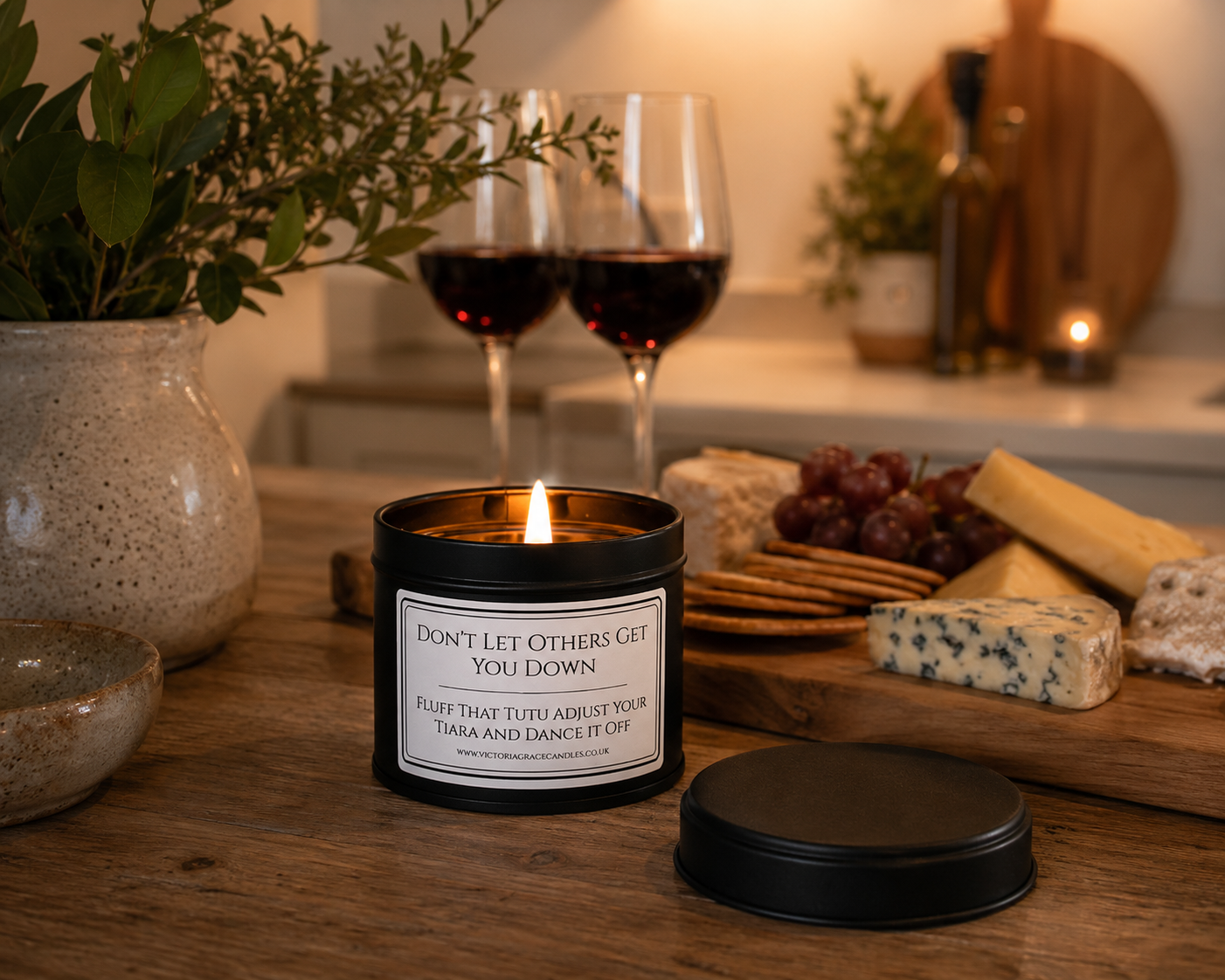 black tin candle with the words don't let others get you down on it set in a cosy environment