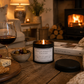 black tin candle with the words don't let others get you down on it set in a cosy sitting room with a log burner in the background