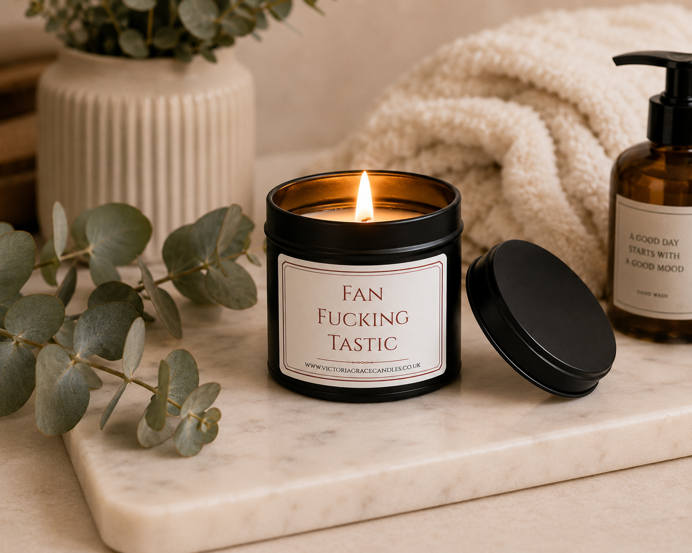 Luxury soy wax candle displayed on a marble tray with eucalyptus, soft blankets and spa-inspired home décor, creating a calm and luxurious atmosphere.