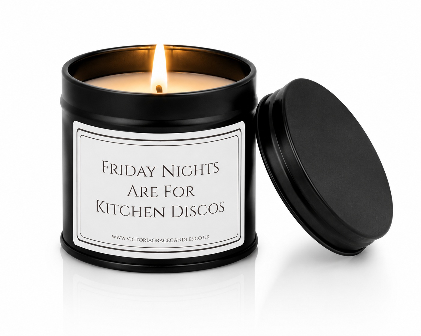 A black metal candle tin with a lit candle and its lid leaning against it on a white background. The front label reads 'FRIDAY NIGHTS ARE FOR KITCHEN DISCOS' with a small website at the bottom.