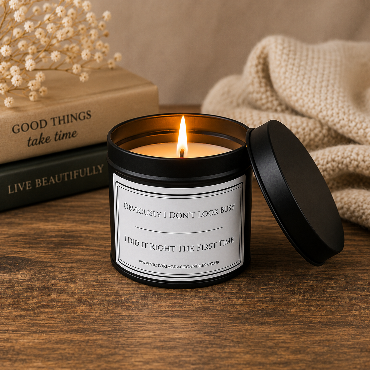 Funny soy wax candle in a matte black tin styled with books and home décor by Victoria Grace Candles.