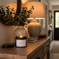 Good Vibes Only candle displayed on a rustic hallway sideboard beside a beautiful table lamp creating a warm welcoming entrance