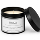 A black metal candle tin with its lid leaning against it, showing a white wax candle and a white label that reads “HOME It’s Not A Place It’s A Feeling.”.