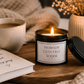 Luxury black soy wax candle creating a warm evening atmosphere with soft lighting, cosy textures and a glass of wine.