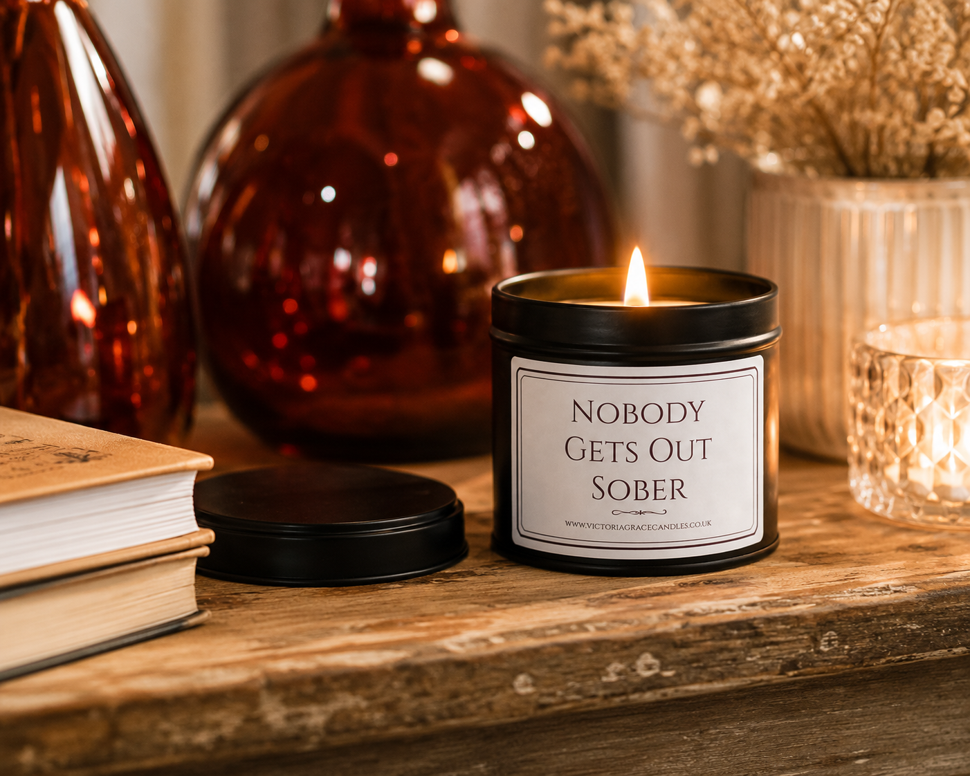 Luxury black soy wax candle on a rustic wooden table with warm home décor, creating a cosy and inviting atmosphere.