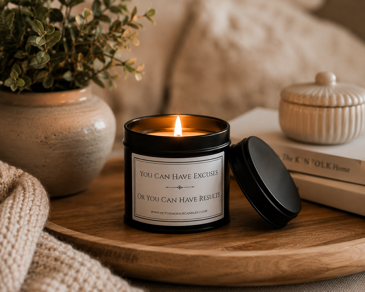 Luxury soy wax candle on a wooden tray surrounded by books, cosy textiles and neutral home décor, creating an inspiring workspace.