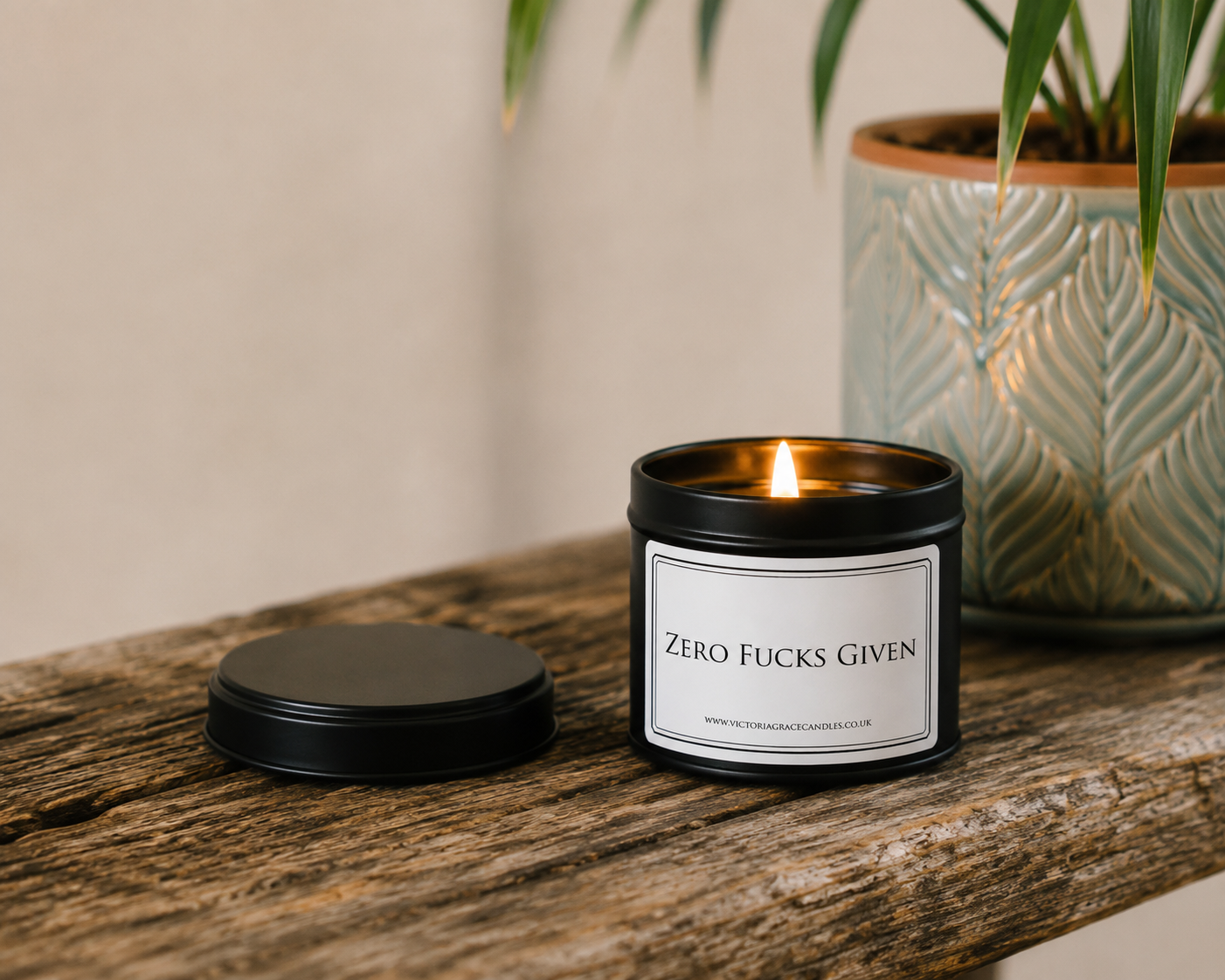 Luxury black soy wax candle displayed on a rustic wooden table with a decorative plant in a relaxed, stylish home setting.