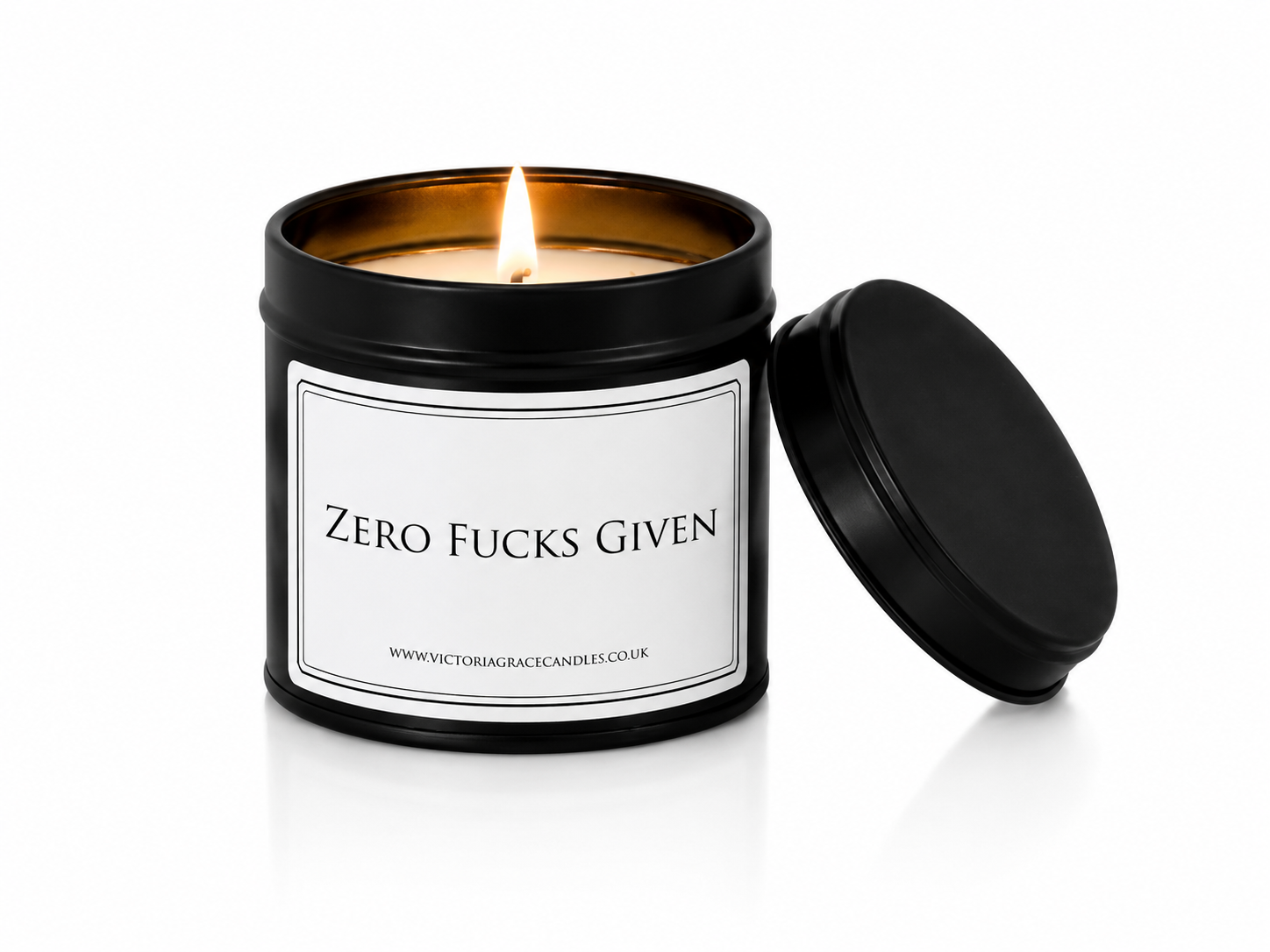 Luxury black soy wax candle with the words "Zero Fucks Given" displayed on a white background with the black lid resting beside the candle.